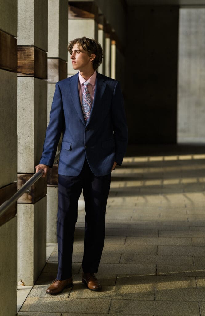 Arkansas senior guy in suit posing at Crystal Bridges. 