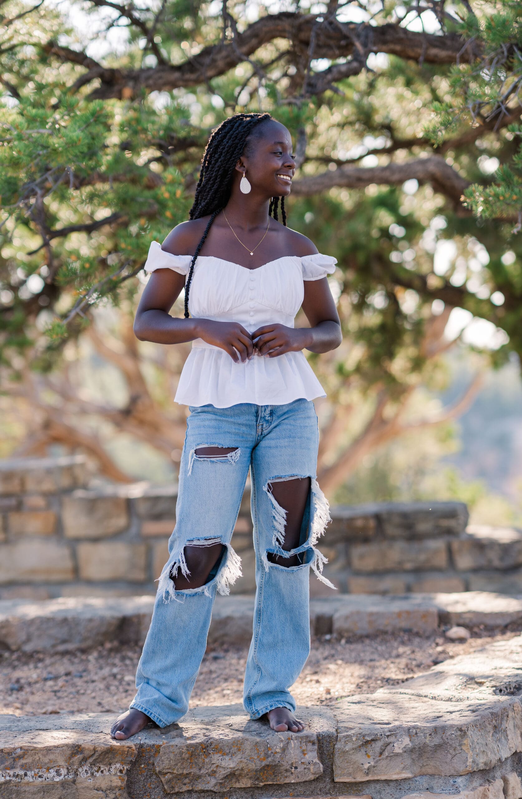 Arkansas senior girl in white top posing under a tree.
