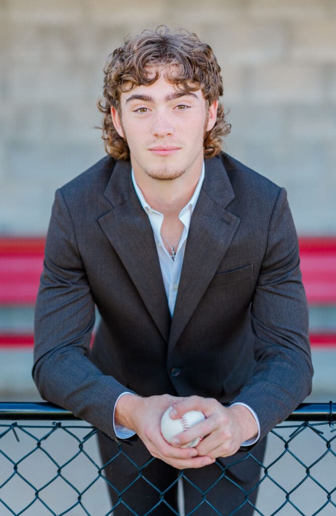 Arkansas senior in suit with baseball.