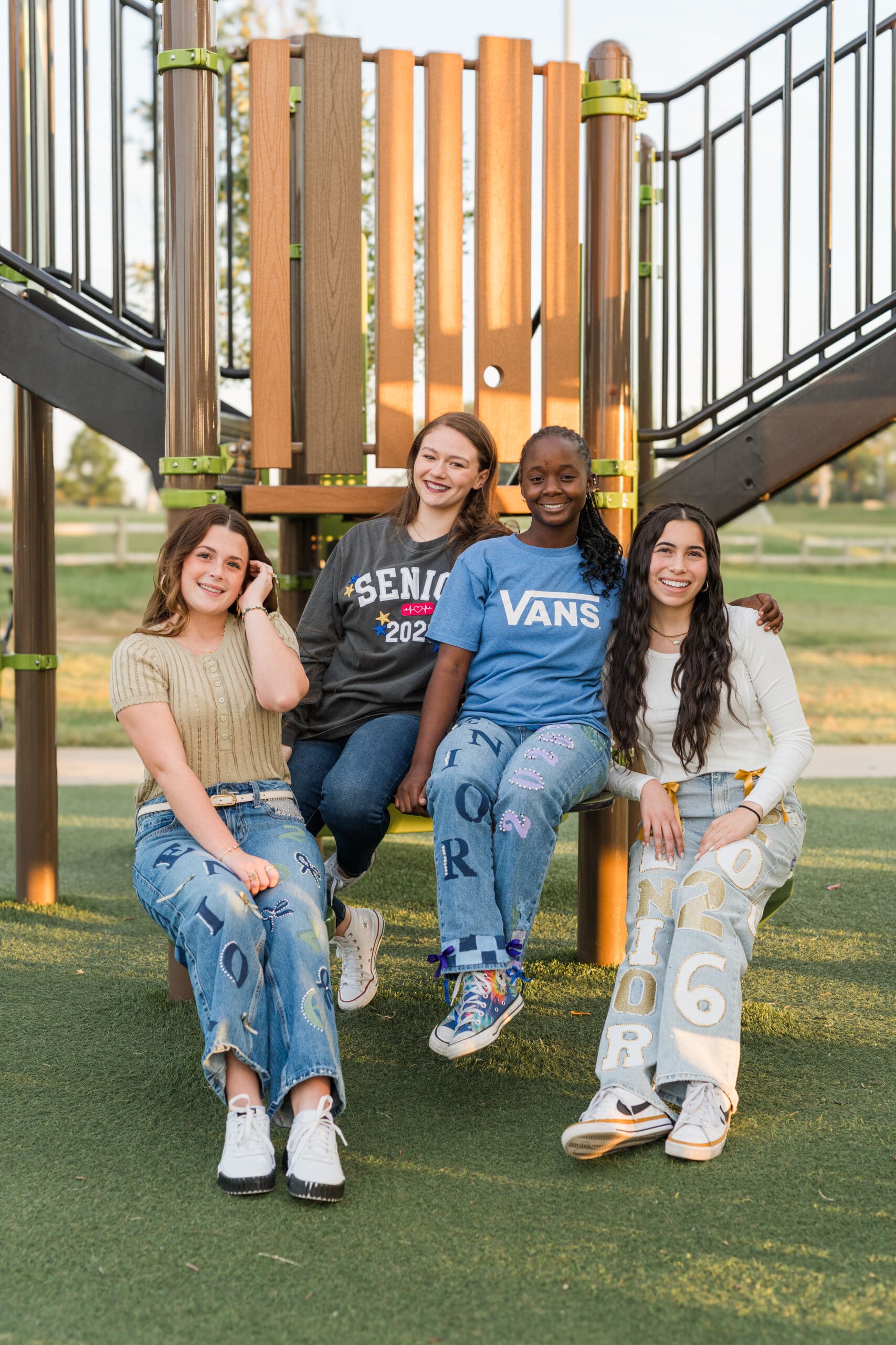 Arkansas senior girls wearing senior jeans and posing at a playground.